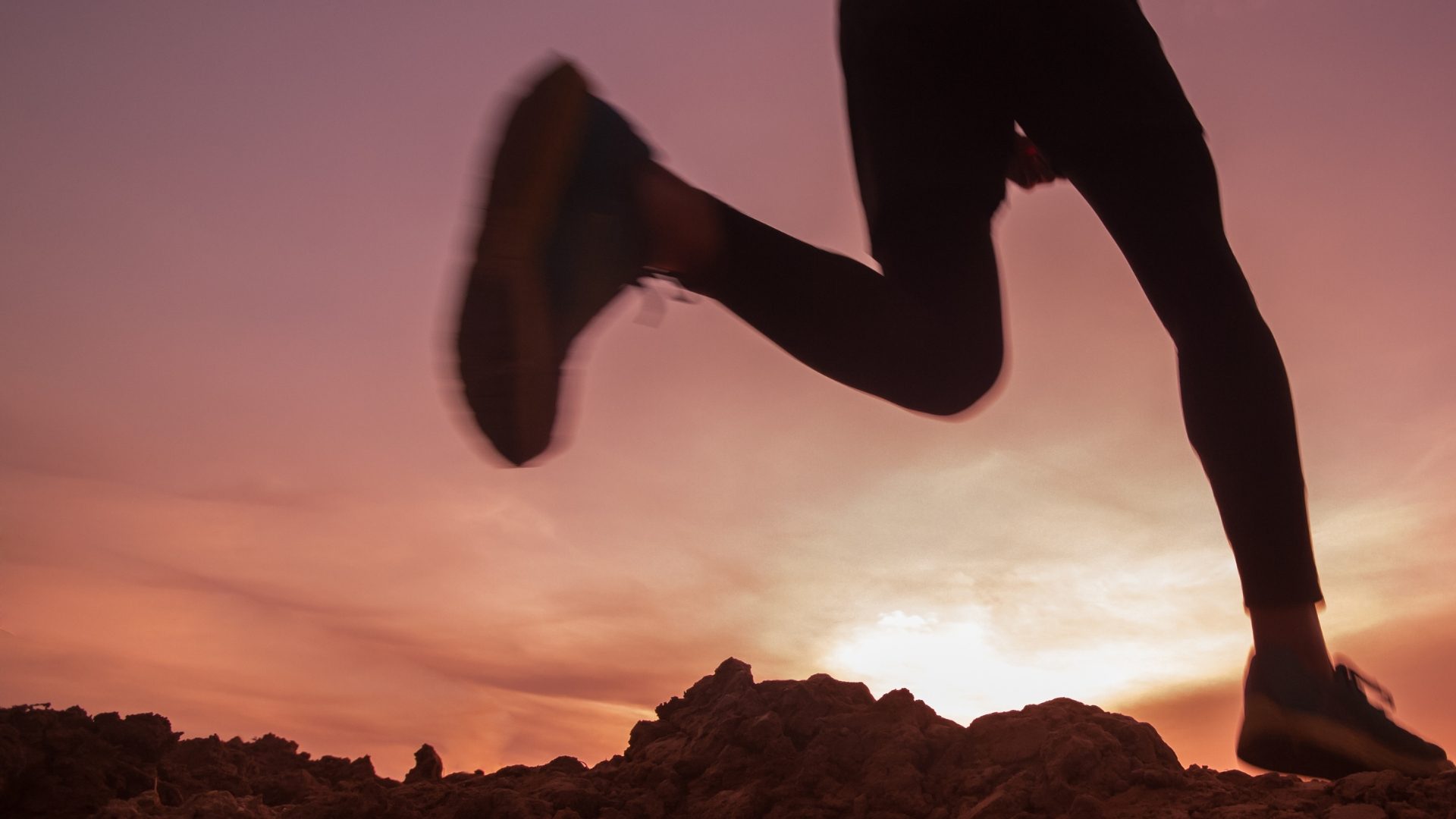 A runner silhouetted against a sunset